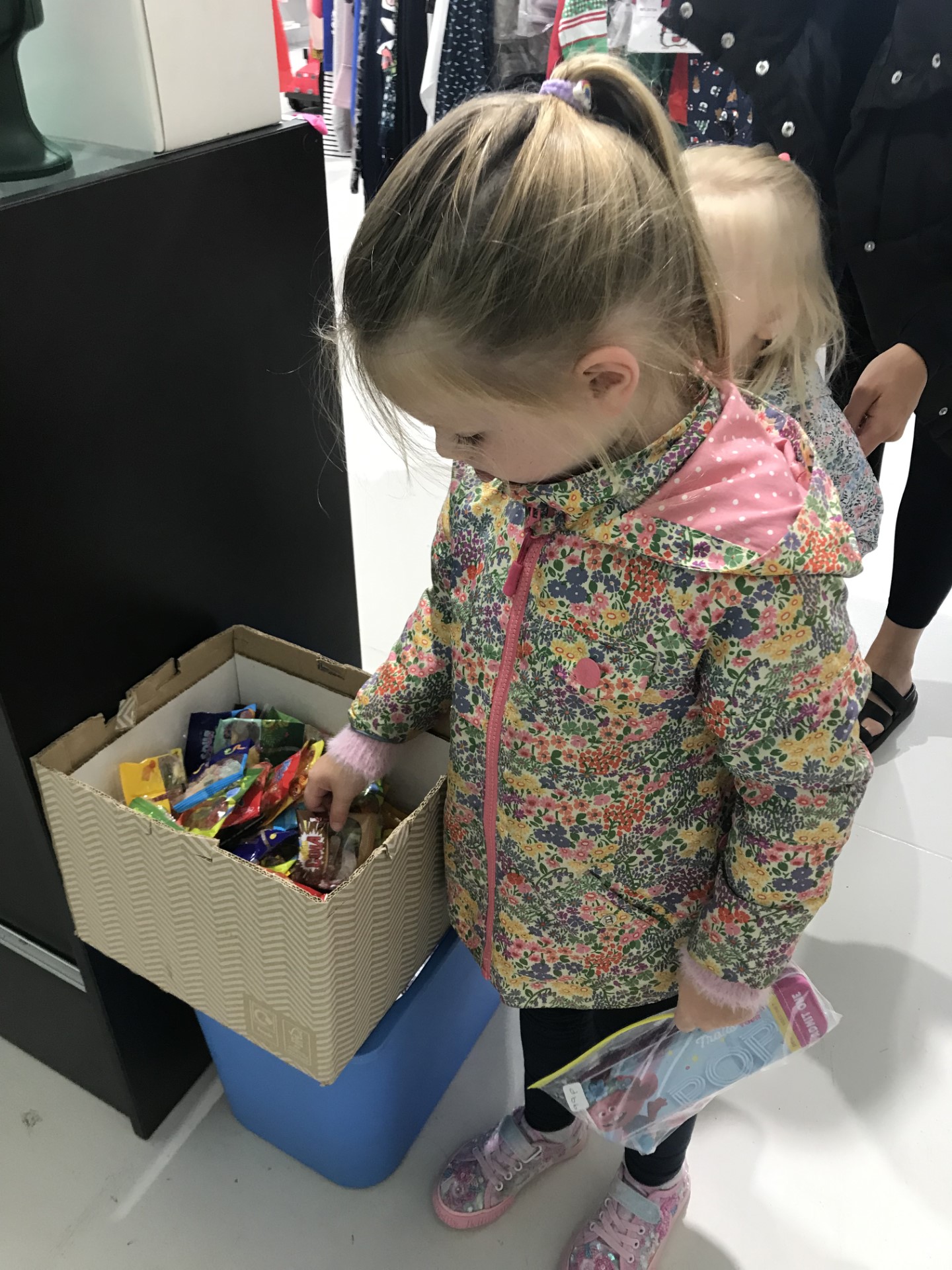 A child looking in a box of bargains.