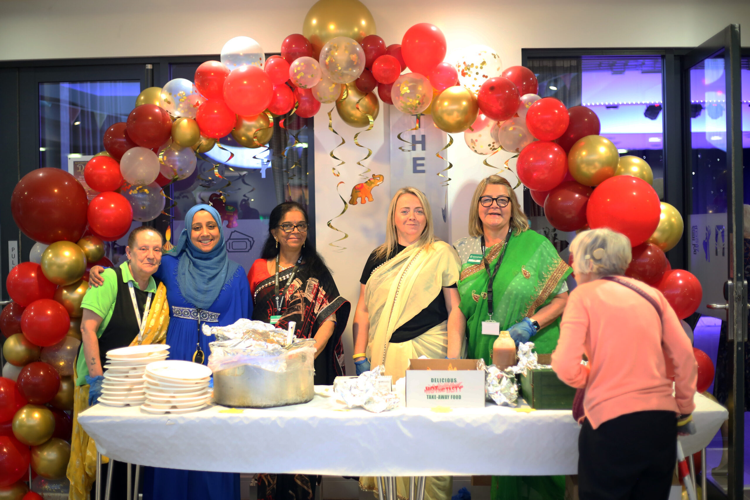 Staff serving indian food to attendees.