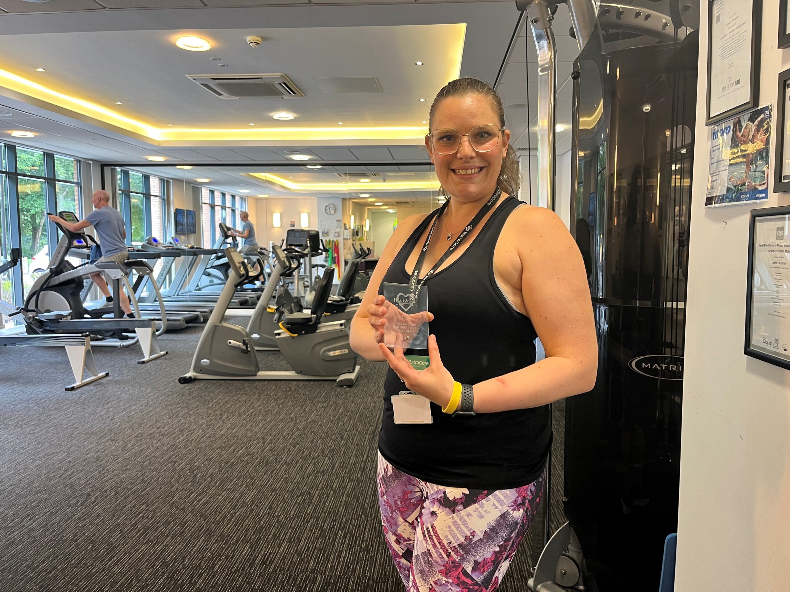 Lyndsey at the gym holding the award.