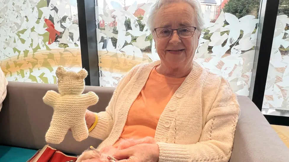 Resident Jennie holds her knitted teddy bear.